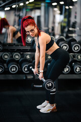 fitness woman training with heavy weights in fitness gym. Female athlete holding barbell gym workout