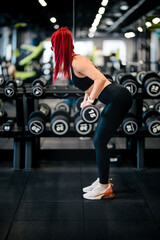 Fototapeta na wymiar fitness woman training with heavy weights in fitness gym. Female athlete holding barbell during back workout