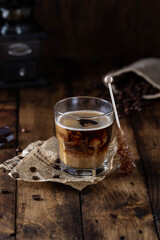 Glass of hot coffee with milk on wooden table