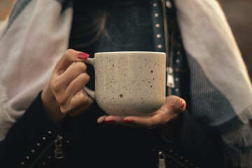 Young woman holding a Cup of hot tea outside