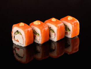 Traditional delicious fresh sushi rolls on a black background with reflection. Sushi menu, japanese kitchen.