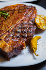 Grilled t-bone steak on plate.Delicious beefsteak cooked on grill for dinner in American meat...