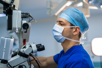 Neurosurgeon is operating with medical robotic surgery machine. Manual control by minimally...