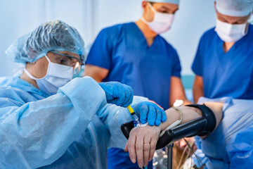 Hand of a patient lying on the operating table. Pulse oximeter sensor on the finger. The patient is...