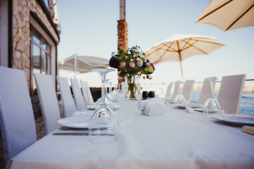Rustic table setting with purple flowers and glass of red wine on light wooden table. Holidays decoration on Provence style. Romantic dinner. Top view