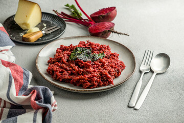beetroot risotto with hard cheese, caramelized leaves,  dark black background