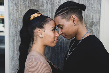 African American lesbian couple touching foreheads in tender moment together