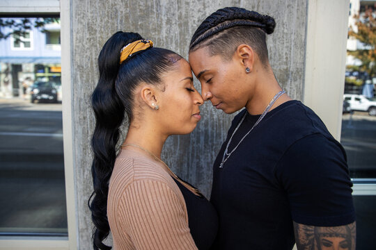 African American lesbian couple touching foreheads in tender moment together