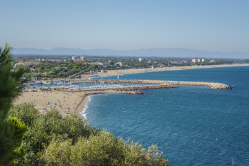 Naklejka premium Sandy Mediterranean beach Le Racou in Argeles sur Mer with its old fishermens houses and the harbor in background, Roussillon, Pyrenees Orientales, France.
