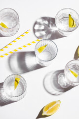 Mineral water with lemon on white background. Hard light