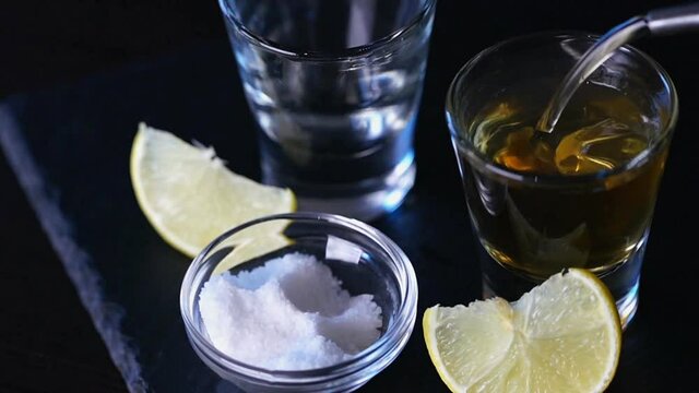 cinemagraph, vodka is poured into a glass on black background