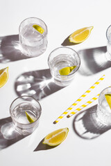 Mineral water with lemon on white background. Hard light