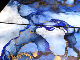 Abstrakter blauer Hintergrund mit schönen Flecken und Flecken aus Alkoholtinte und Goldpigment. Kunstfragment mit blauer Textur ähnelt Aquarell- oder Aquarellmalerei. © Luvricon