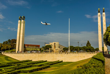 Obraz premium A view towards the top of the King Edward VII park captures an incoming flight in Lisbon, Portugal