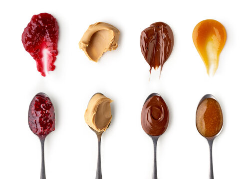 Set of spoons with peanut butter, sweet jams and chocolate nougat cream isolated on white background, top view