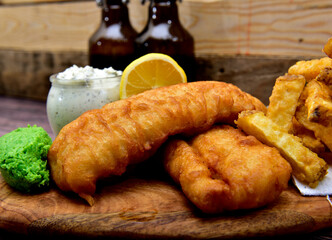 Homemade fish and chips on a wooden tray