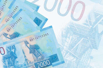 2000 russian rubles bills lies in stack on background of big semi-transparent banknote. Abstract...