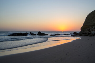 .beach with rocks in golden hour with the sun setting