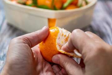 hands peeling tangerine