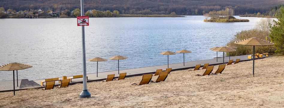 View of the deserted beach with umbrella and deckchairs. Landscape: sea and wave on coast with relaxation view.