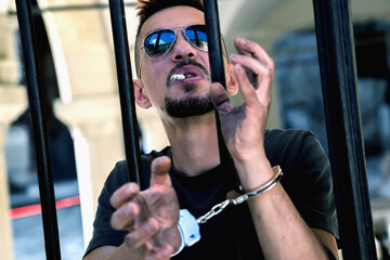 Upset handcuffed man with cigarette imprisoned for crime, punished for serious villainy. Arrest,...