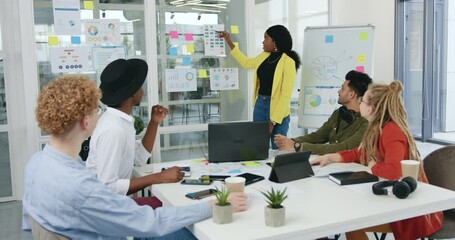 Concept of office work where likable positive successful motivated diverse team discussing strategy of joint project using infographics on glass wall in office room - Powered by Adobe