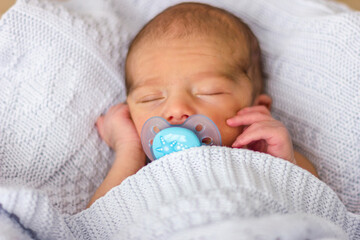 Sleeping newborn baby with pacifier. Baby face close-up.