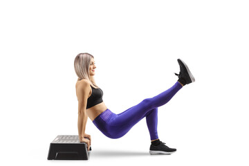 Young blond woman exercising step aerobic