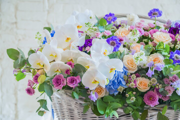 Large floral basket with colorful flowers at workshop, flower shop. Floristry, holiday, romantic, celebration, handmade and small business concept