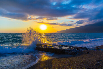 Beautiful shoreline scene with waves at sunset beams