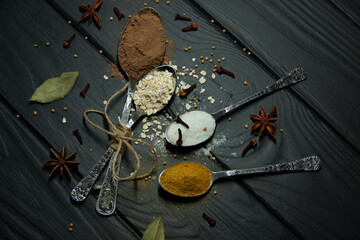 Spoons and spices. Cinnamon, salt, curry, mustard, cloves and star anise