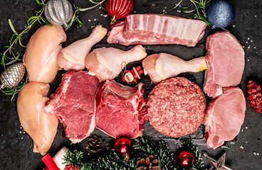 Various types of raw meat beef, pork, chicken for the holiday of Christmas on a stone background...