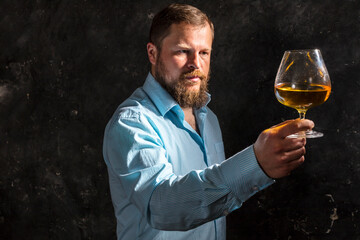Solid bearded man in shirt with glass of whisky