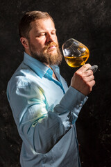 Solid bearded man in shirt with glass of whisky