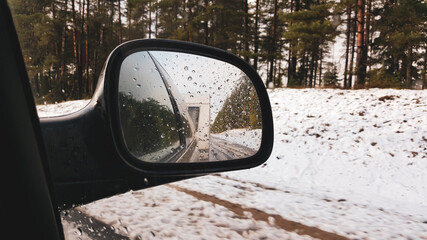 Car with trailer travel trip active vacation on cloud winter day, indoor view from car to front side window to outdoor back view mirror caravan trailer reflection. Winter journey  concept