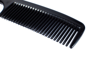 Black comb on white background. Close up.