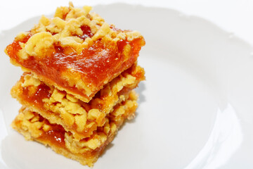 Layered shortbread pie with Apple jam on a white plate. Apple pie