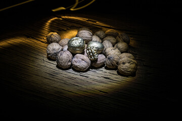Still life with Walnut kernels and whole walnuts on rustic old wooden table. Creative table decoration.