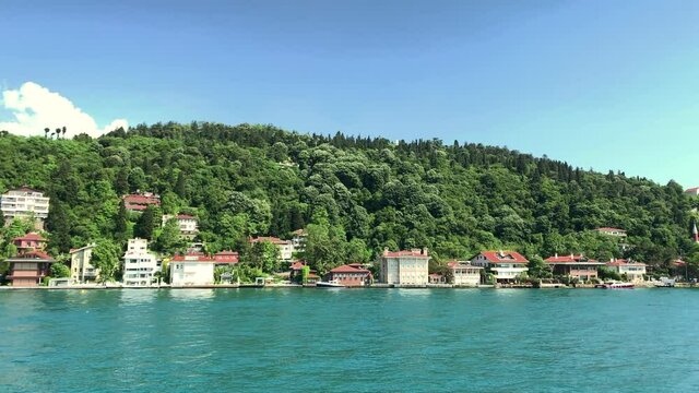 Footage of historical mansions at upscale neighborhood called "Kandilli" in Istanbul. It is a beautiful Bosphorus scene in a sunny summer day. Camera moves forward.