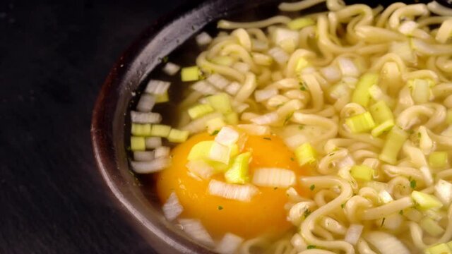 Hot noodle soup with egg and leek.
