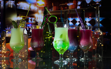 Cocktail glass splashing on dark toned smoky background or colorful cocktail in glass. Party club entertainment. Mixed light. Selective focus