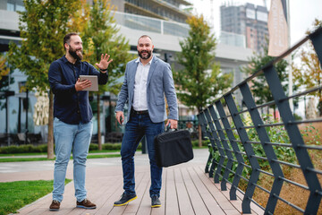 Young business people standing  with tablet and discussing about plans for the future of the company 