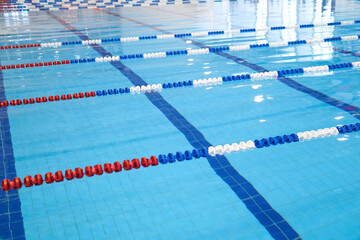 fragment of the competition pool with blue water and marked swimming lanes