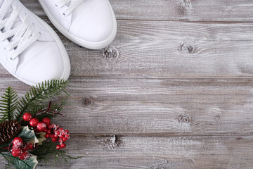 Fototapeta premium White snikers and christmas decor on wooden background with copy space as a concept of xmas sale, discount and shopping