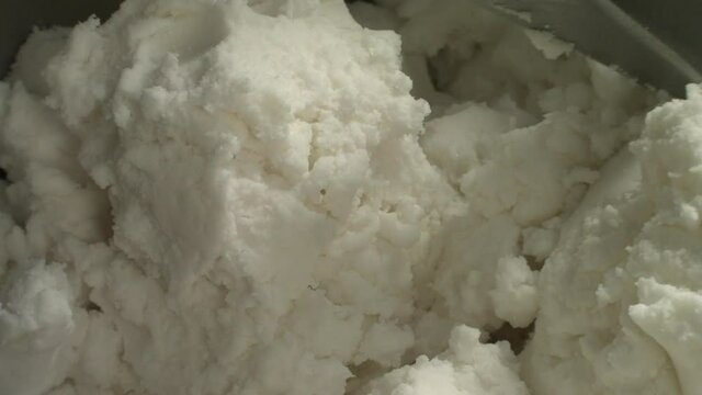 Top view a thick curd mass is mixed in a mixer using a metal nozzle. Concept for the exquisite taste of cottage cheese, delicious protein foods and fresh fillings for baking