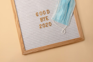 Letter board with title - good bye 2020.Blue medicine mask on it.Forgiveness with the current year concept.Creative layout.