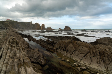 Fototapeta na wymiar rocky and wild coast with stormy waves hitting the shore