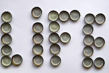 Many soda bottle caps on endless white ground, no alchool yes life, 
The word life, consisting of alcohol caps, 
isolated used glass bottle caps made of metal on white ground 