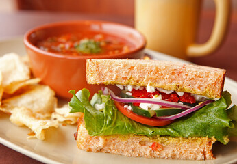 Vegetarian half sandwich and tomato soup with potato chips at a local cafe