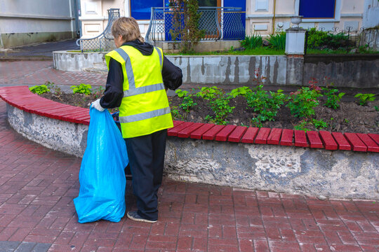 Woman The Cleaner Collects Garbage . Sanitation Worker Sweep Street